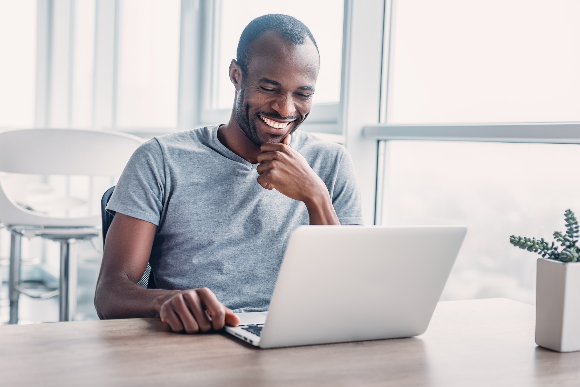 Young businessman working on his laptop in spacious bright office